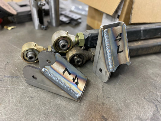 Welded 4Link4WD lower control arm brackets with control arms in background.