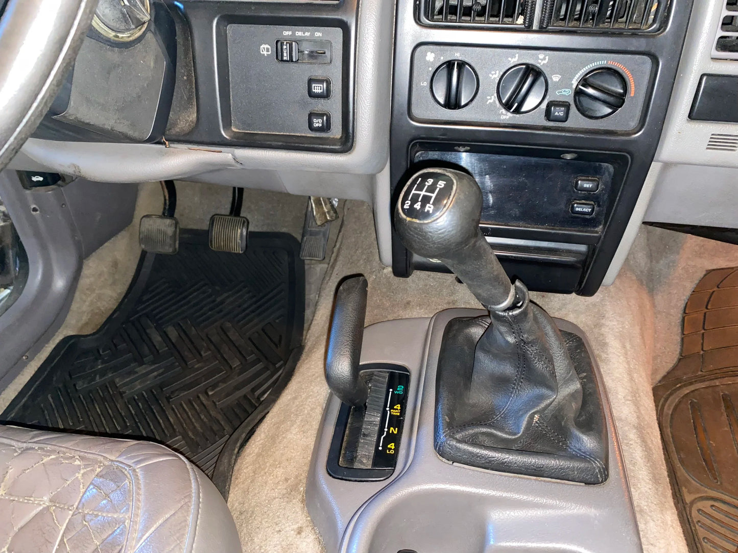 Manual transmission ZJ interior showing finished product with shifter boot in place, above inner dust boot kit.
